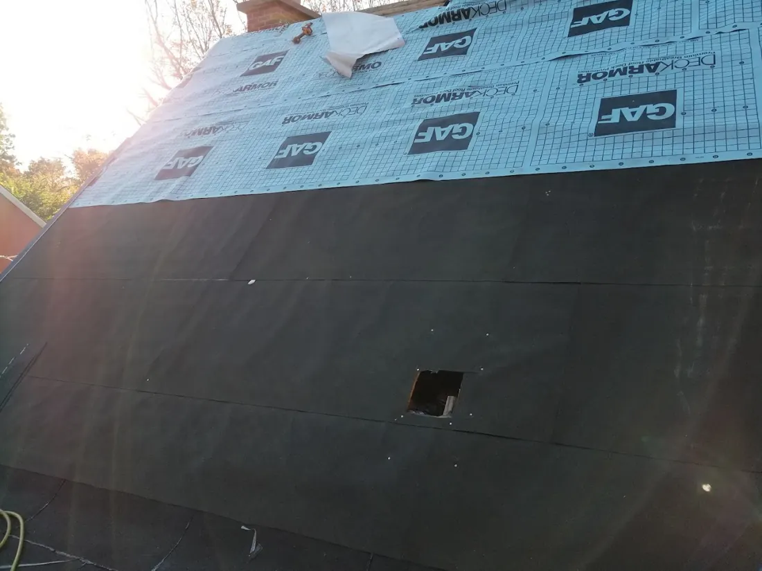 Stainless steel chimney pipes through a shingled roof with flashing